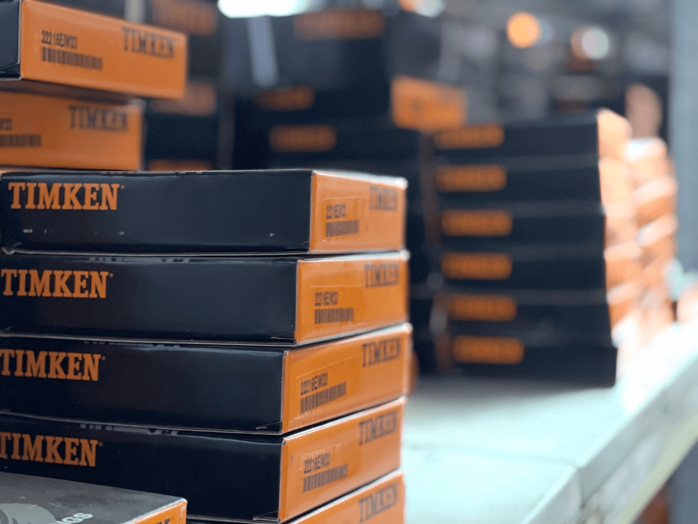 A warehouse aisle with shelves stocked with boxes of industrial parts.